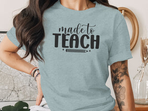 Light blue t-shirt with "made to TEACH" text and a pencil graphic.