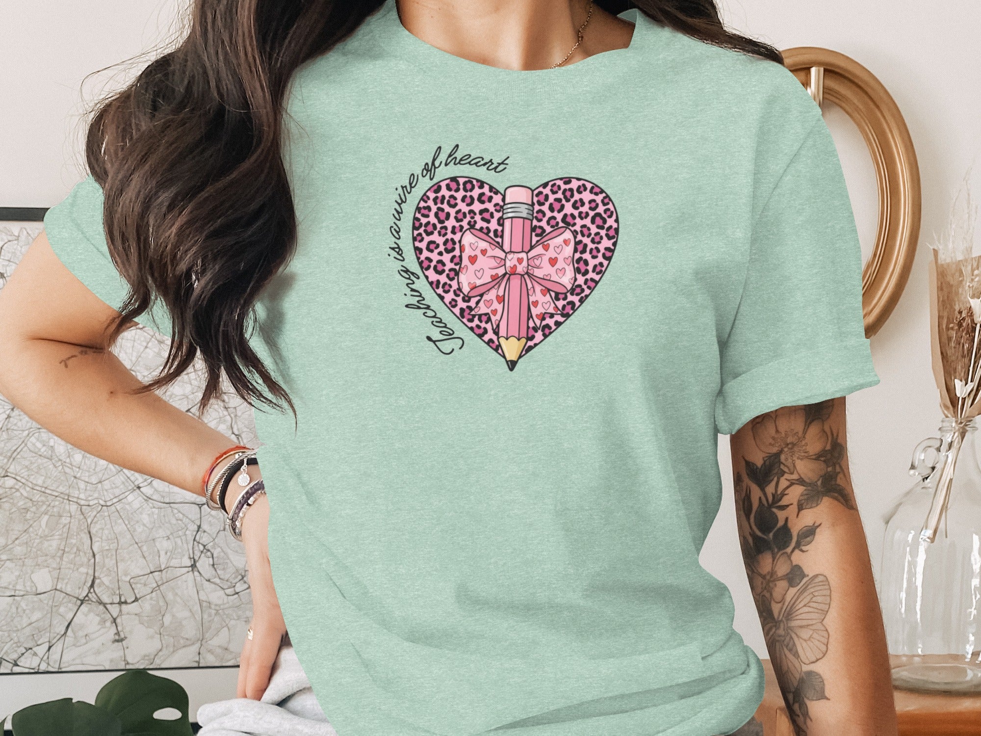 Heart graphic with leopard print, pink pencil, and bow. "Teaching is a wire of heart" text.