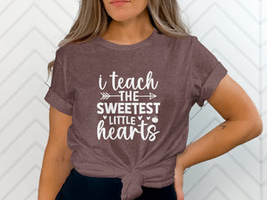 Brown t-shirt with white text reading "i teach THE sweetest little hearts."