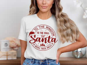 White t-shirt with red circular graphic: "To the window to the wall til Santa decks these halls"