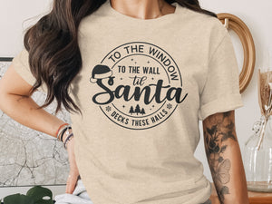 Cream t-shirt with "To the window to the wall 'til Santa decks these halls" Christmas graphic.