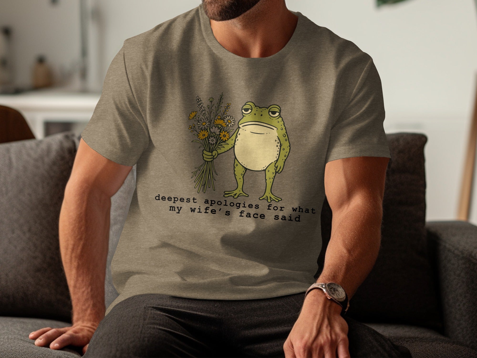 T-shirt with a disgruntled frog holding flowers and the text "deepest apologies for what my wife's face said."