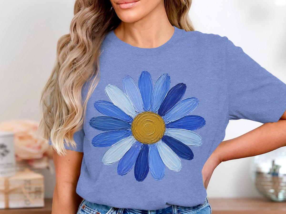 Blue t-shirt with a textured blue daisy graphic and gold center.