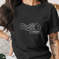Black t-shirt with white postcard stamp graphic and text "SUMMER IS IN THE AIR".