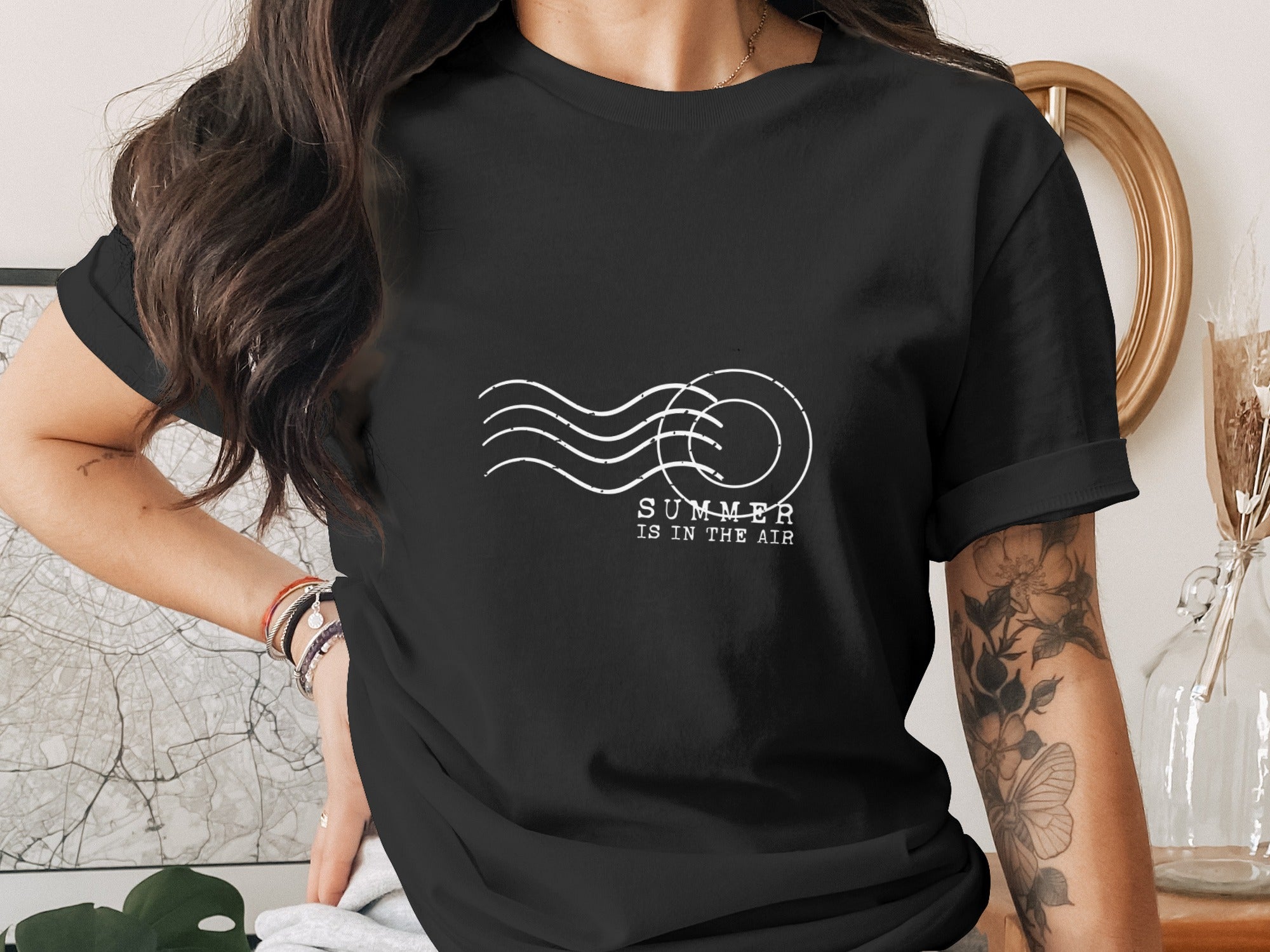 Black t-shirt with white postcard stamp graphic and text "SUMMER IS IN THE AIR".