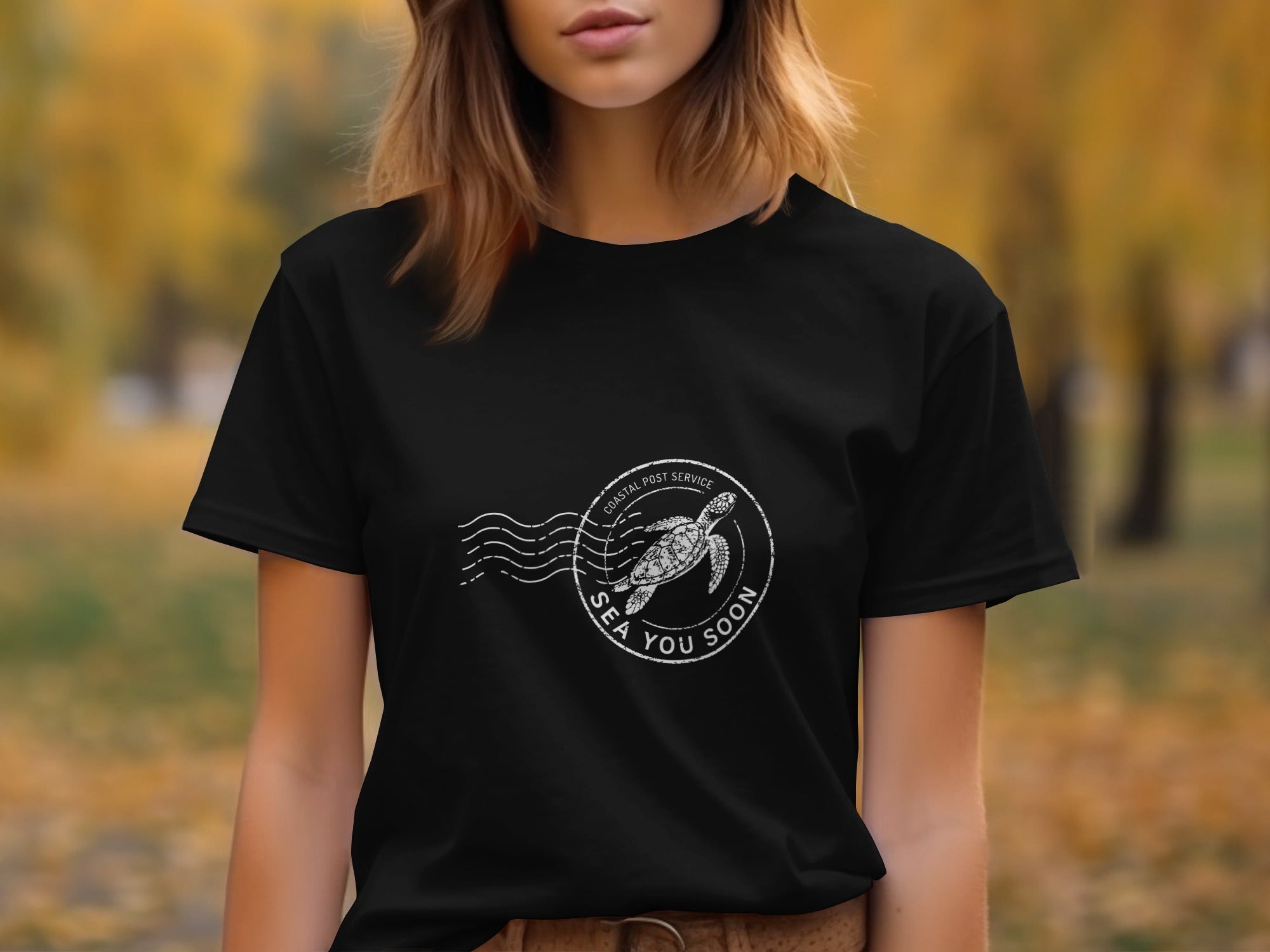 Black t-shirt with a white circular stamp graphic of a sea turtle and text.