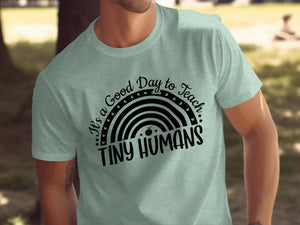 Light green t-shirt with black text "It's a Good Day to Teach Tiny Humans" and rainbow graphic.