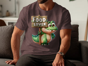 Cartoon alligator holding a "Food Lover" sign on a t-shirt.