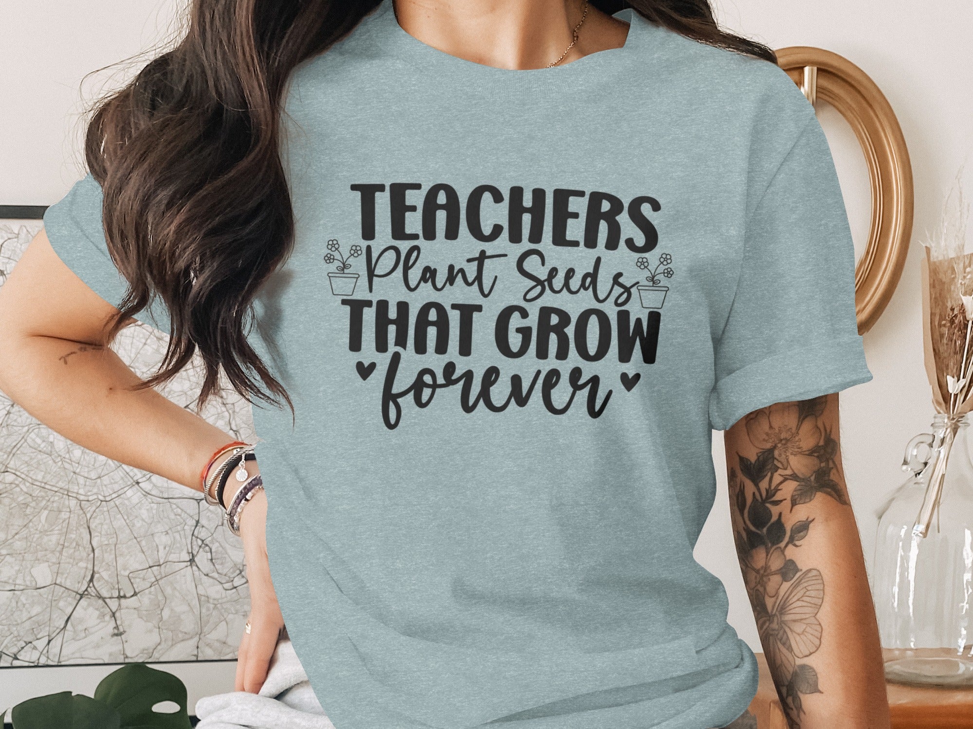 Light blue t-shirt with "Teachers Plant Seeds That Grow forever" black text and floral accents.