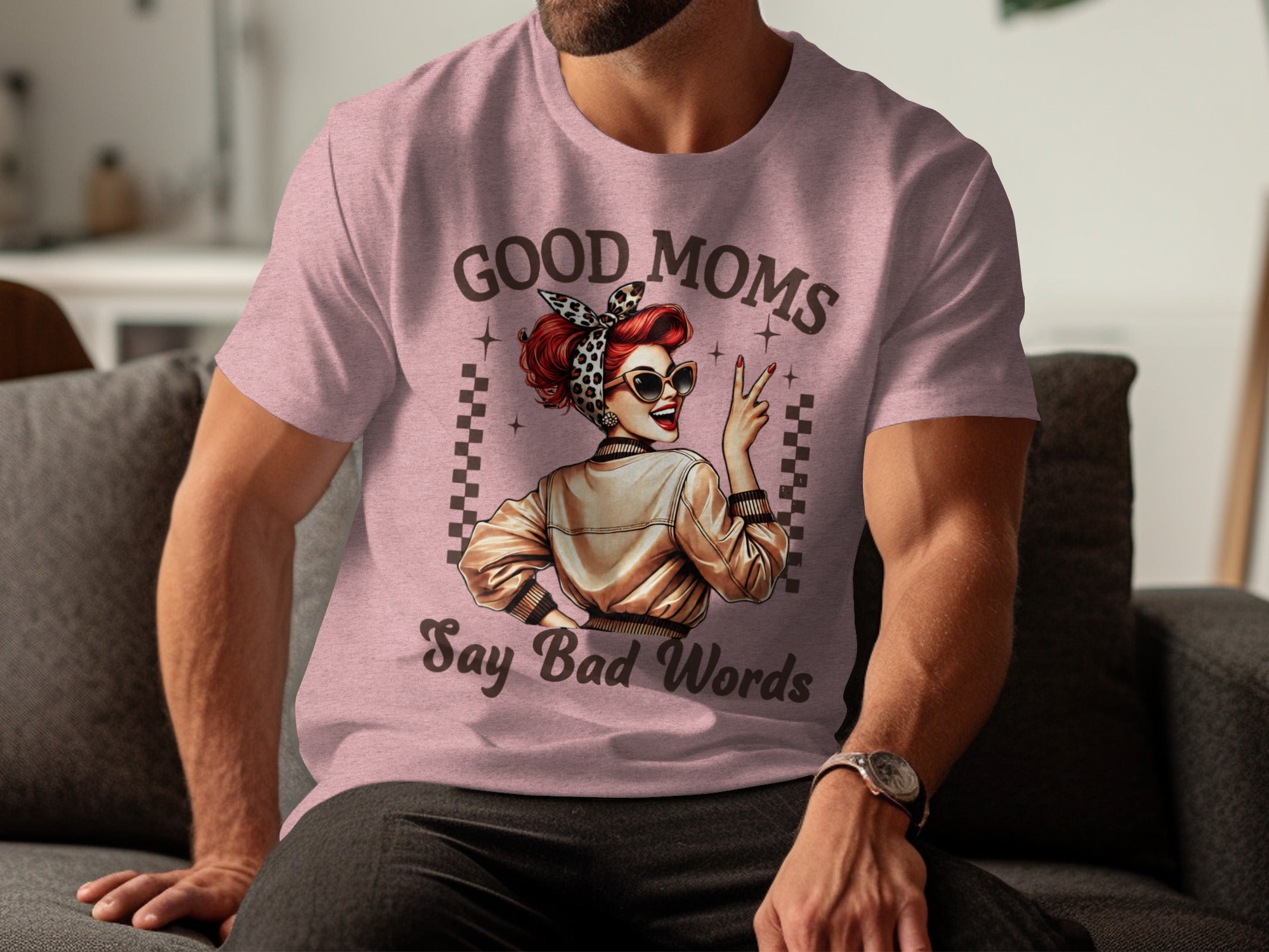 Pink t-shirt featuring "GOOD MOMS Say Bad Words" text and retro pin-up illustration.