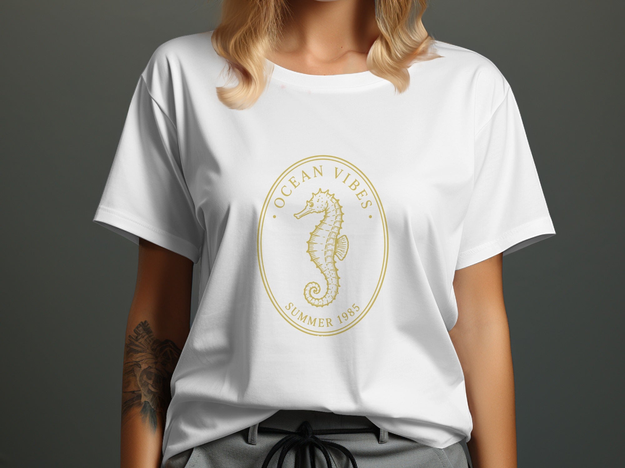 White t-shirt with a gold oval seahorse logo reading "Ocean Vibes Summer 1985".