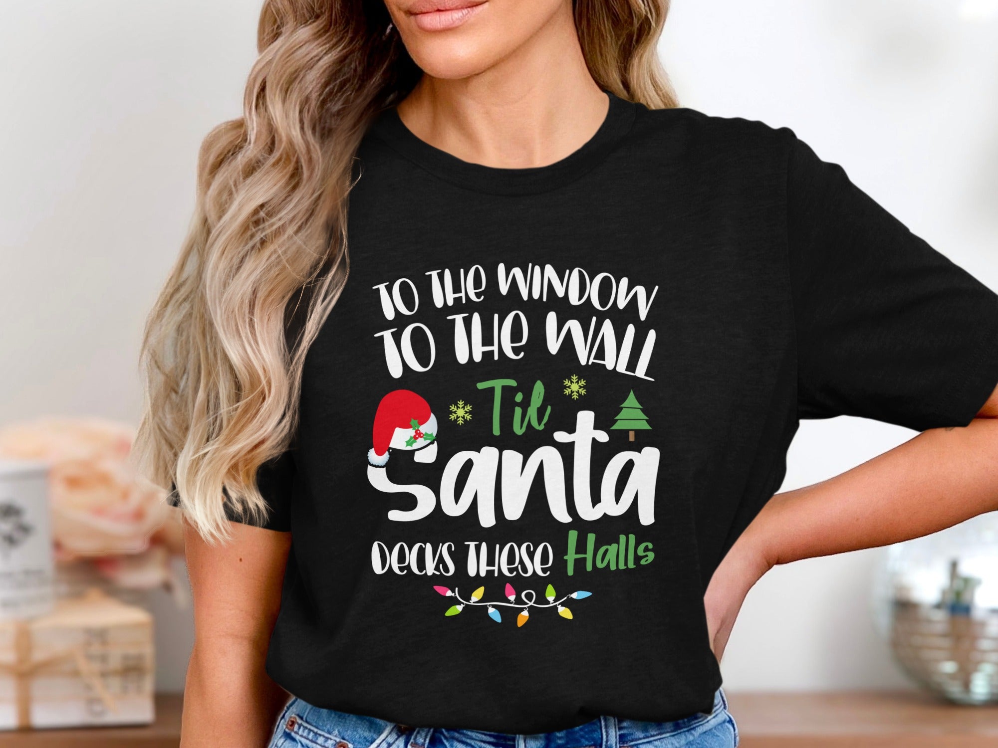 Black t-shirt with white text "To the window to the wall 'til Santa decks these halls."