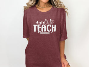 Maroon t-shirt with "made to TEACH" and a pencil graphic.