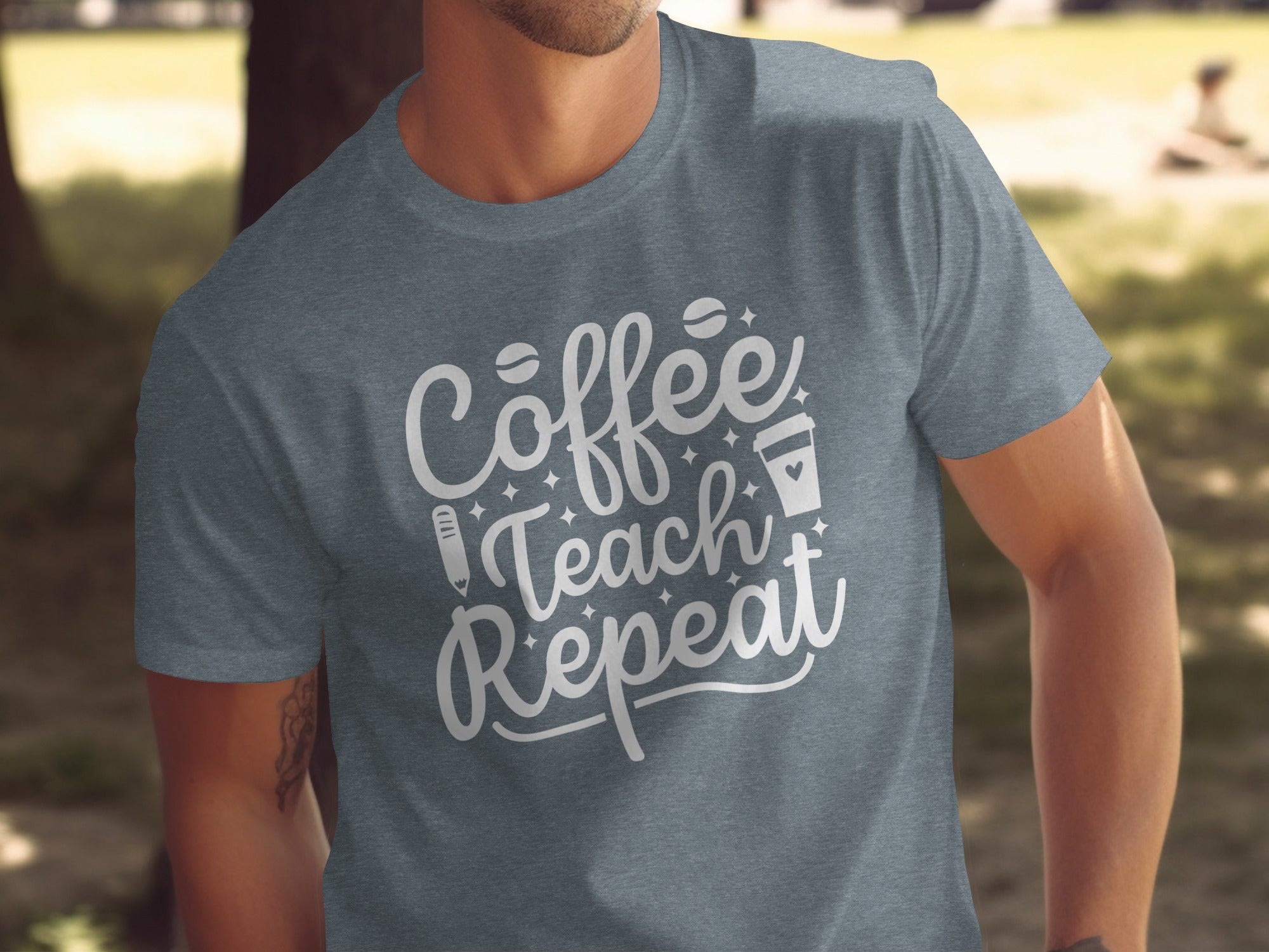 Grey t-shirt with white text "Coffee Teach Repeat," coffee beans, pencil, and cup.