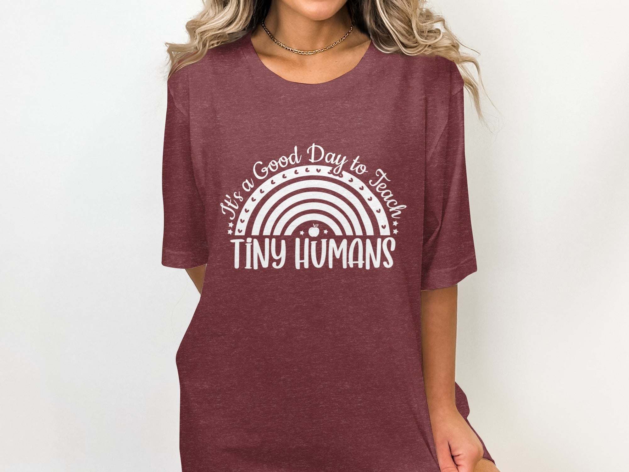Maroon t-shirt with white text and rainbow graphic that reads "It's a Good Day to Teach Tiny Humans".