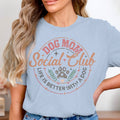 Light blue t-shirt with "Dog Mom Social Club" and paw print graphic.