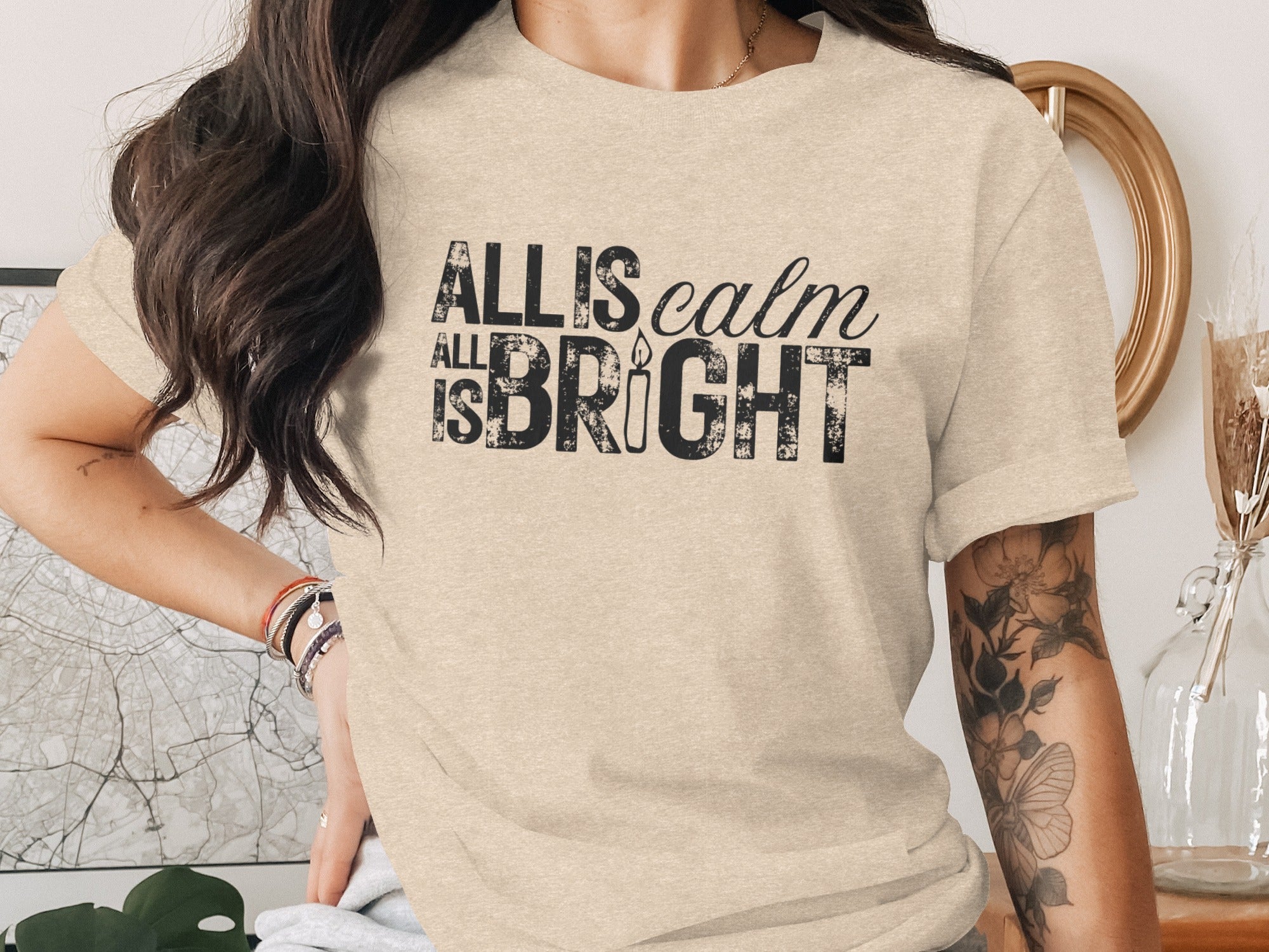 T-shirt with "All is calm, All is bright" text and candle graphic.