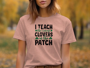 Pink t-shirt with black text "I TEACH the cutest CLOVERS in the PATCH" and shamrocks.