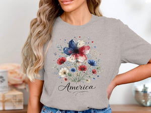 Gray t-shirt with a floral print featuring red, white, and blue flowers and the word "America".