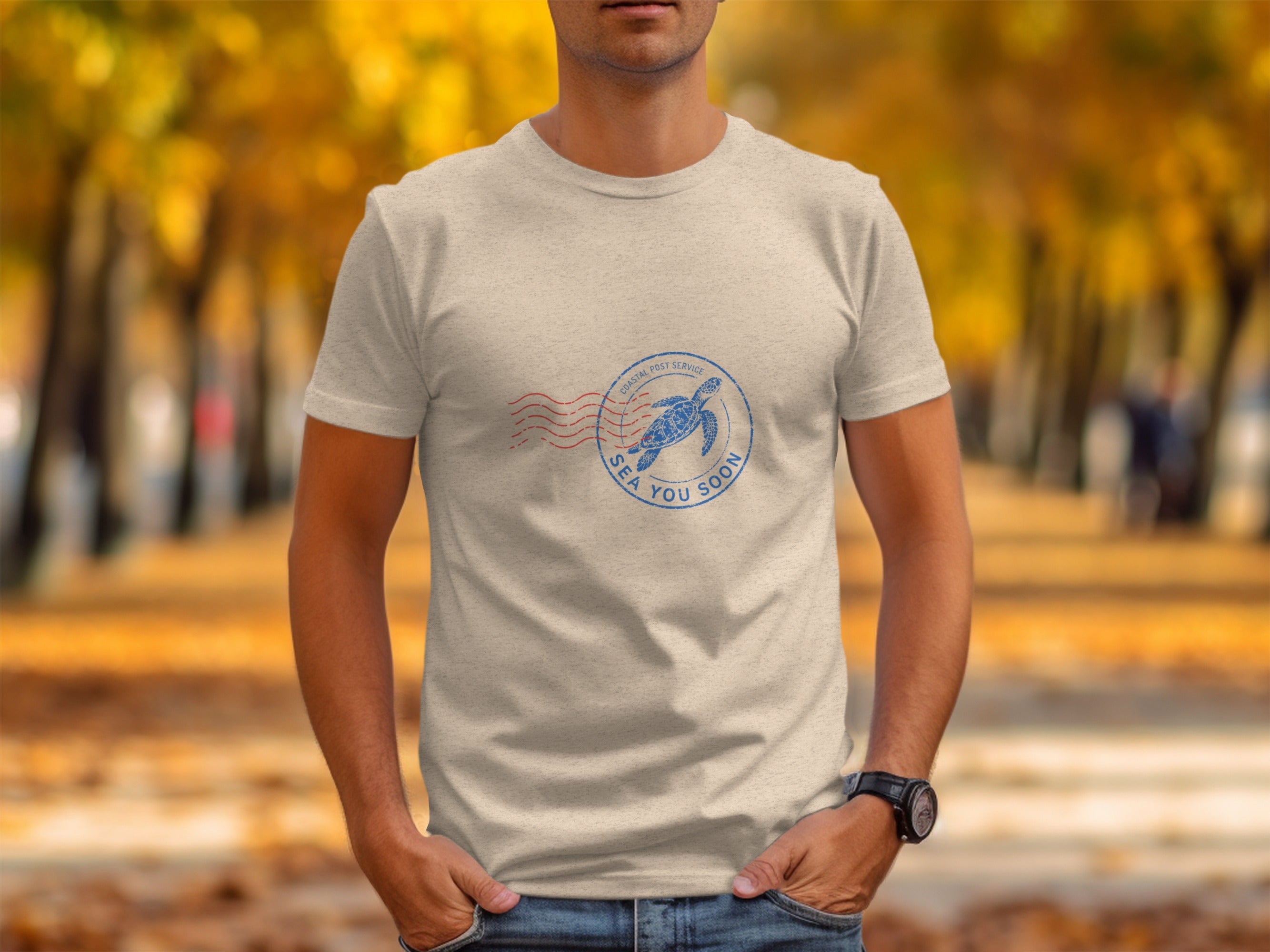 T-shirt with a blue stamp featuring a sea turtle and "SEA YOU SOON" text.