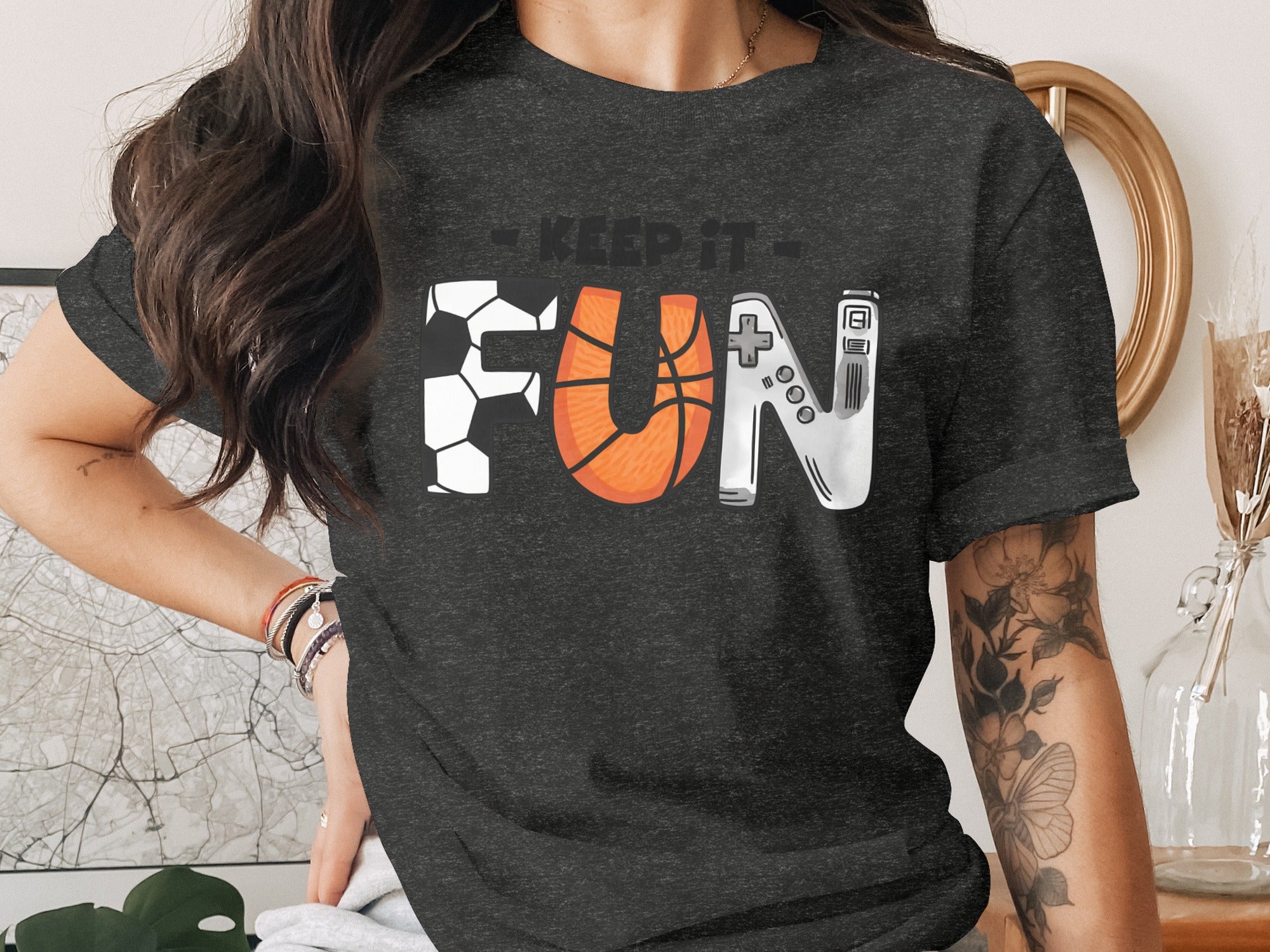 Dark grey t-shirt with "Keep It Fun" text, with letters styled as soccer ball, basketball, and controller.