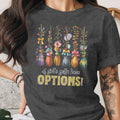 Dark t-shirt with floral brooms and text "A girl's gotta have OPTIONS!".