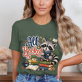Cute raccoon reading books with "All Booked" text on a green shirt.