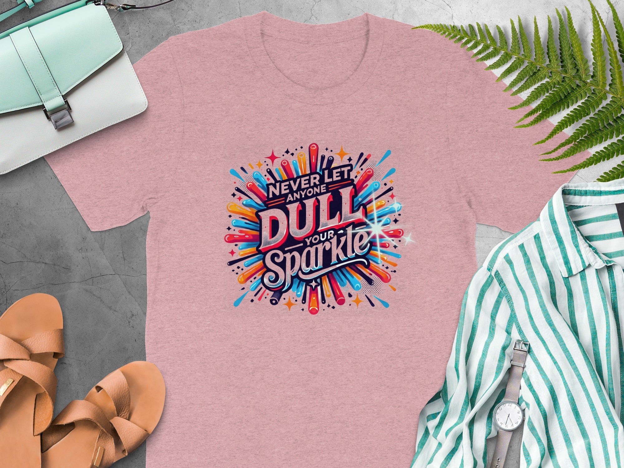 Pink t-shirt with "Never let anyone dull your sparkle" graphic.
