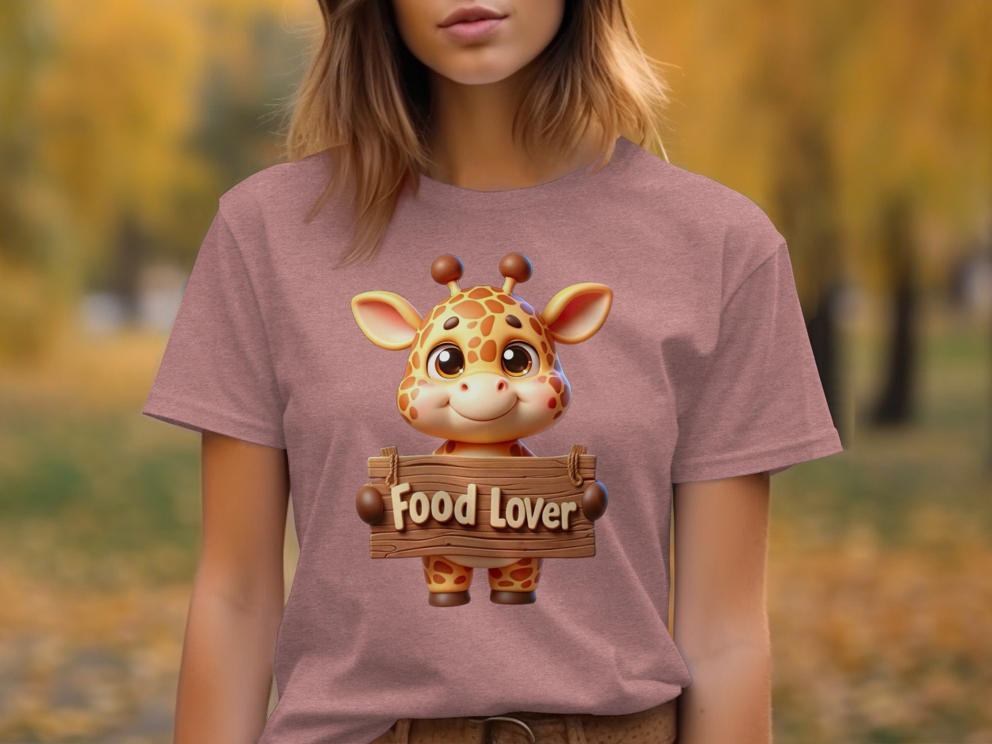 Cartoon giraffe holding a "Food Lover" sign on a pink t-shirt.