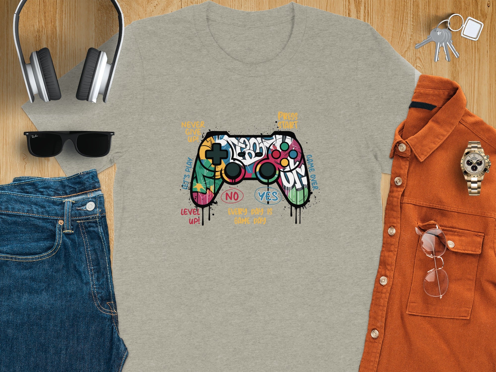 Gray t-shirt with graffiti-style video game controller graphic and text.
