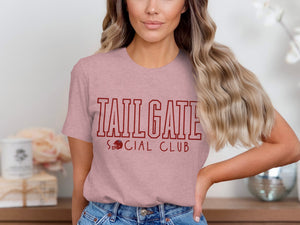 Pink t-shirt with maroon text "TAILGATE SOCIAL CLUB" and a football helmet.