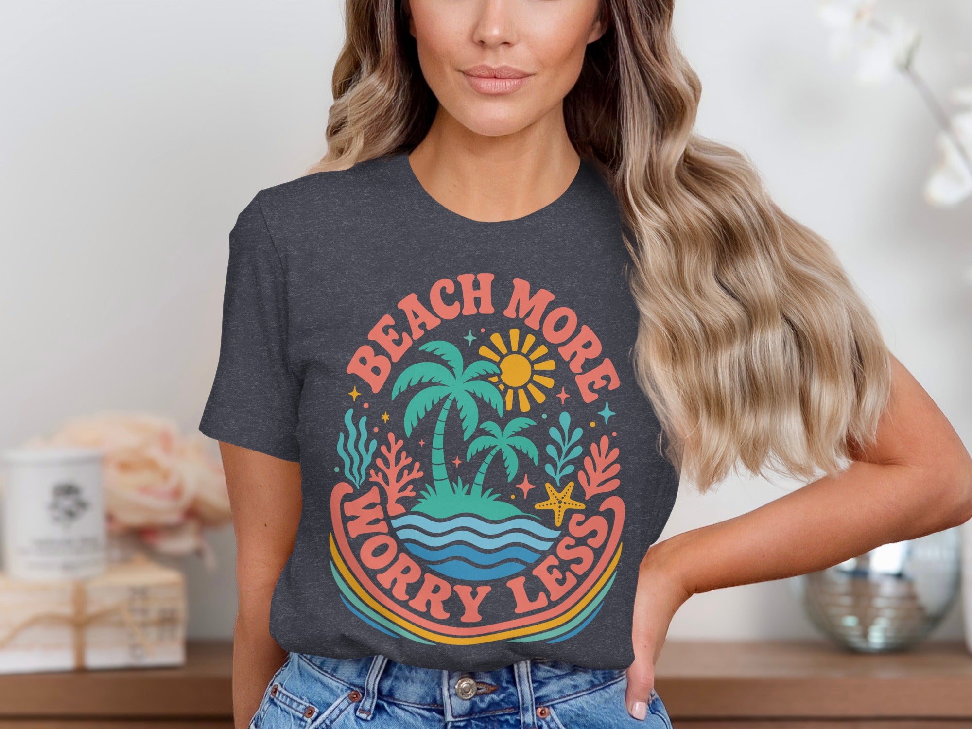Dark grey t-shirt with retro beach graphic and text "Beach more worry less".