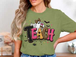 Green t-shirt with "TEACH" text featuring a ghost and Halloween graphics.