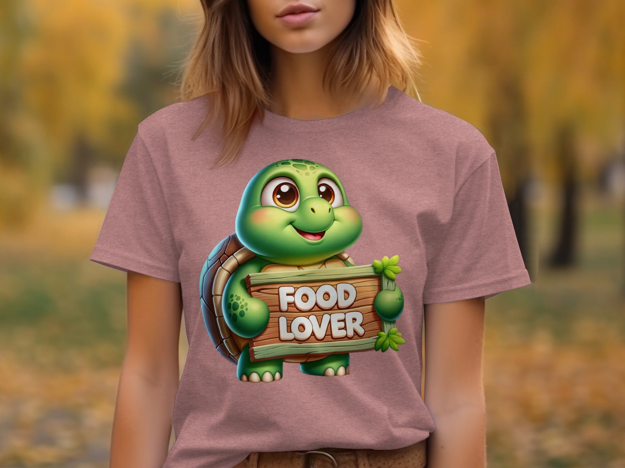 Cartoon turtle holding a "FOOD LOVER" sign on a pink t-shirt.
