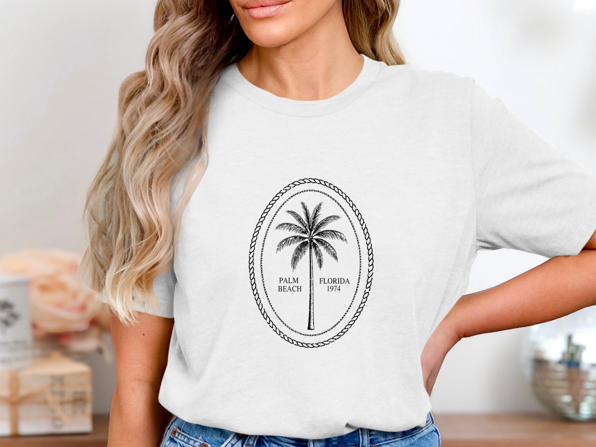 White t-shirt with oval logo featuring a palm tree and text "Palm Beach Florida 1974".