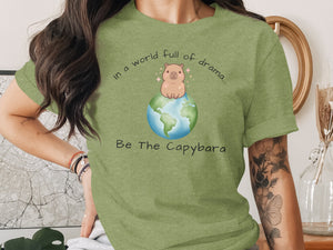 Green t-shirt with capybara on Earth, "In a world full of drama... Be The Capybara".