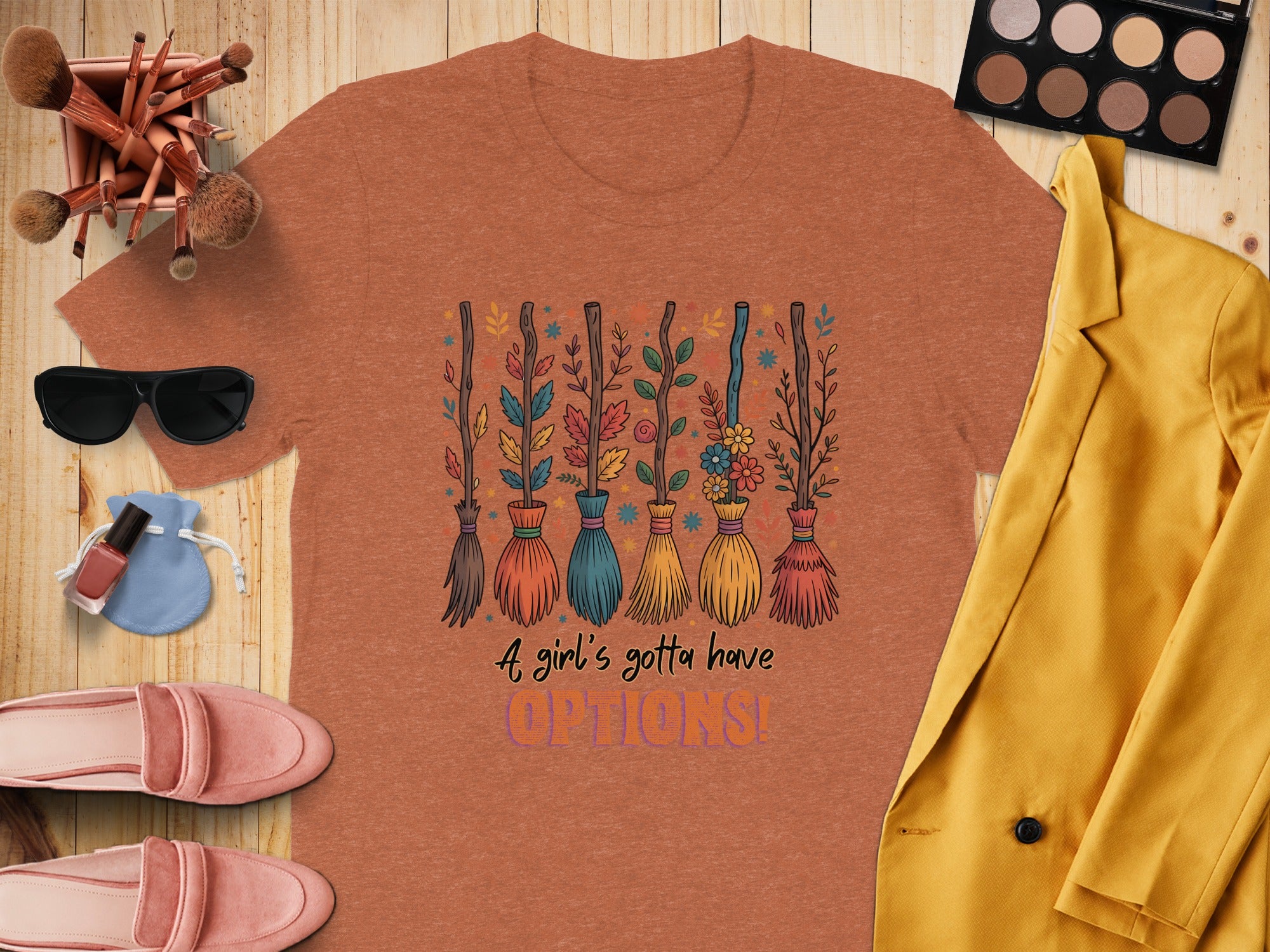 Orange t-shirt with colorful brooms and "A girl's gotta have OPTIONS!" text.