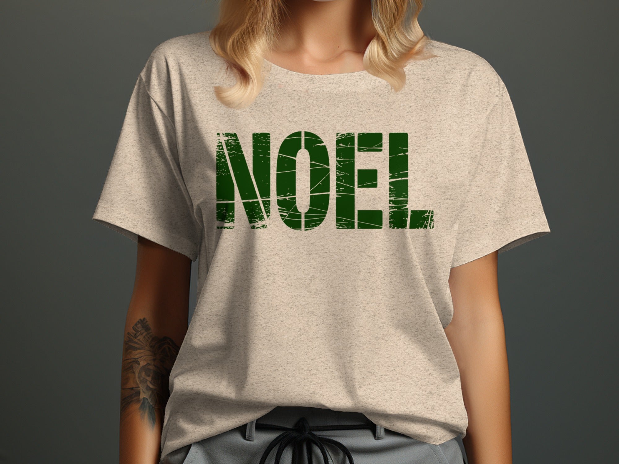 Light gray t-shirt with distressed green "NOEL" text across the chest.
