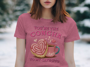 Pink t-shirt with graphic of heart-shaped concha, coffee cup, and text "You're the Concha to my Cafecito".