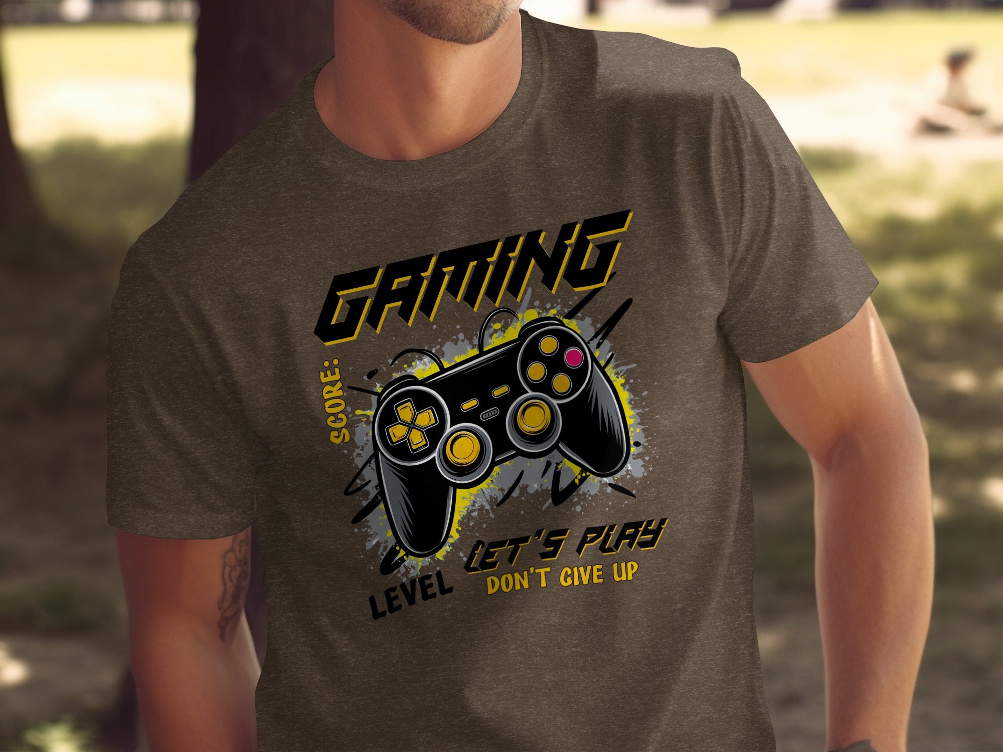 Brown t-shirt with "GAMING" text, video game controller, and "LEVEL DON'T GIVE UP" text.
