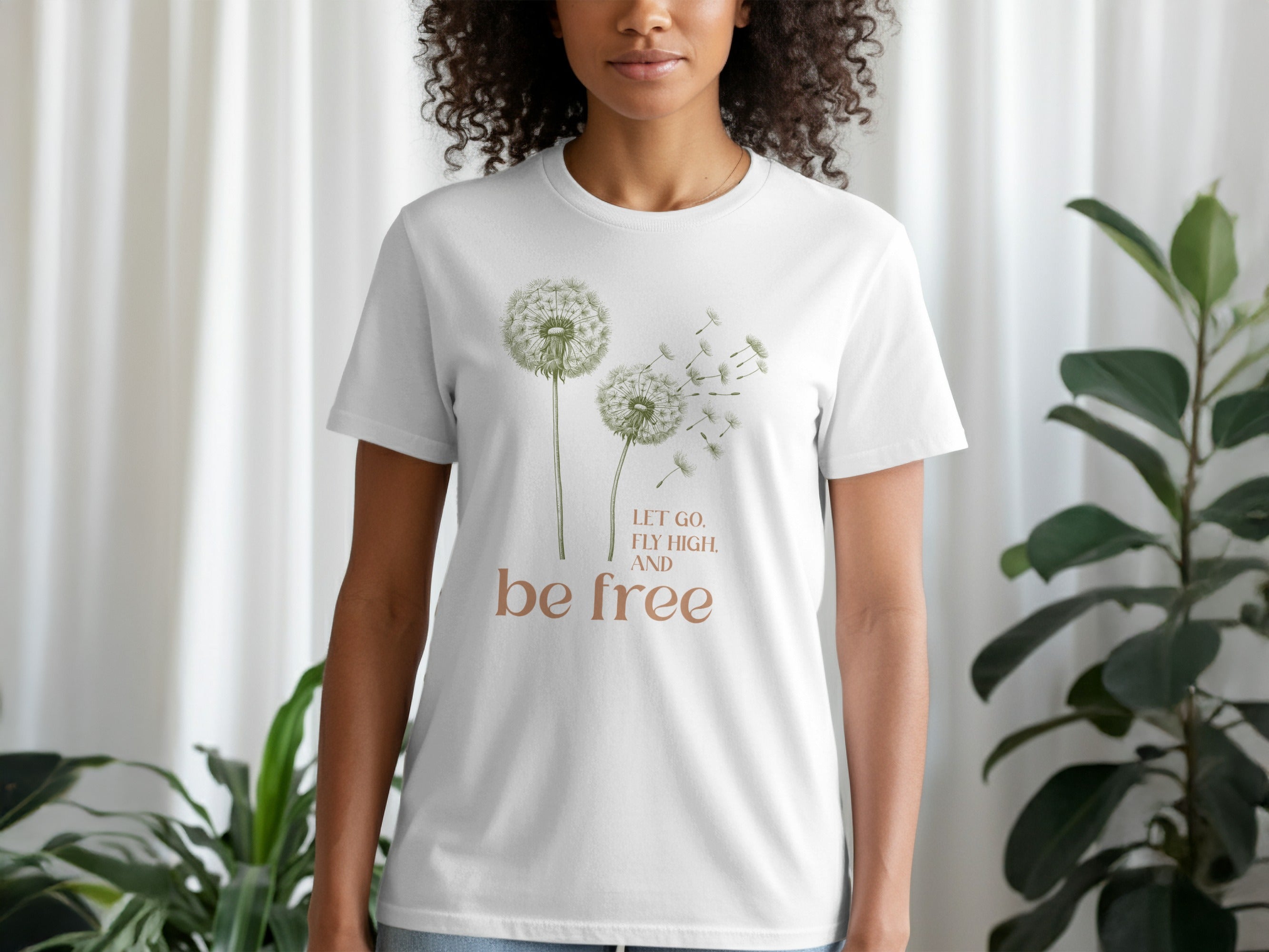 White t-shirt with dandelion graphic and text "Let go, fly high, and be free".