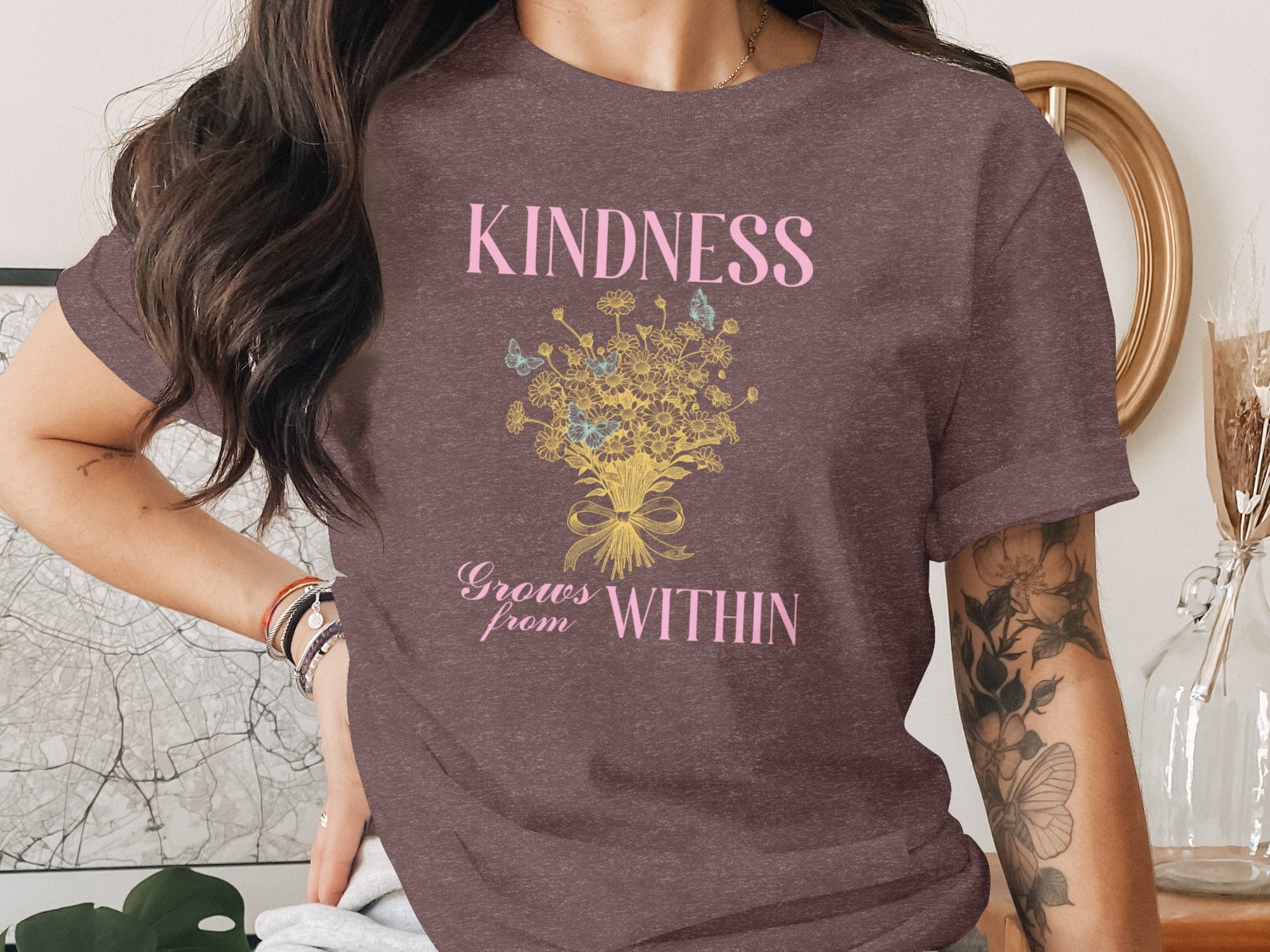 Brown t-shirt with pink text "KINDNESS Grows from WITHIN" and floral design.