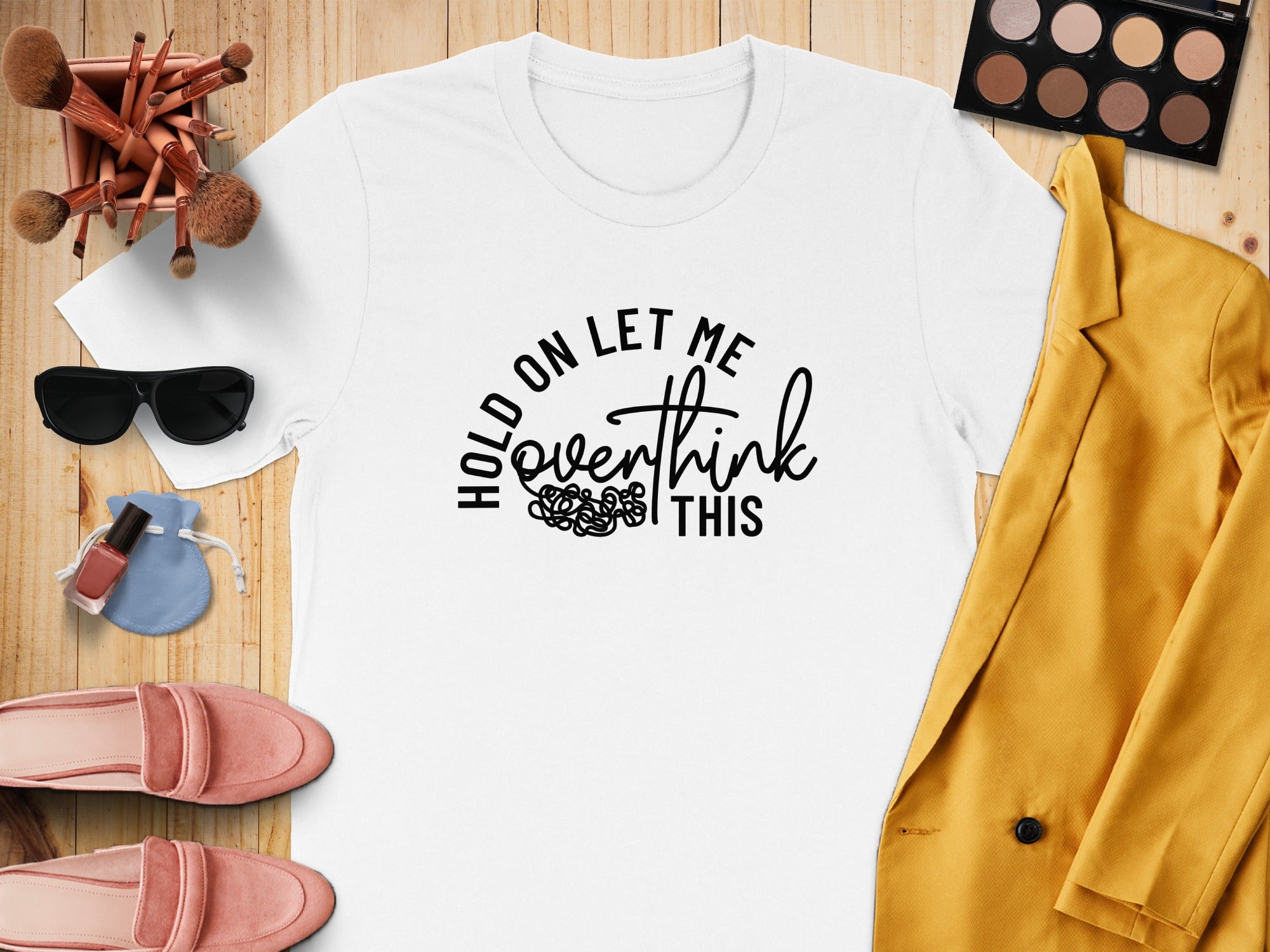 White t-shirt with "Hold on let me overthink this" graphic, flat lay.