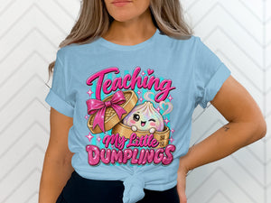 Light blue t-shirt with a cartoon dumpling and text "Teaching My Little Dumplings".