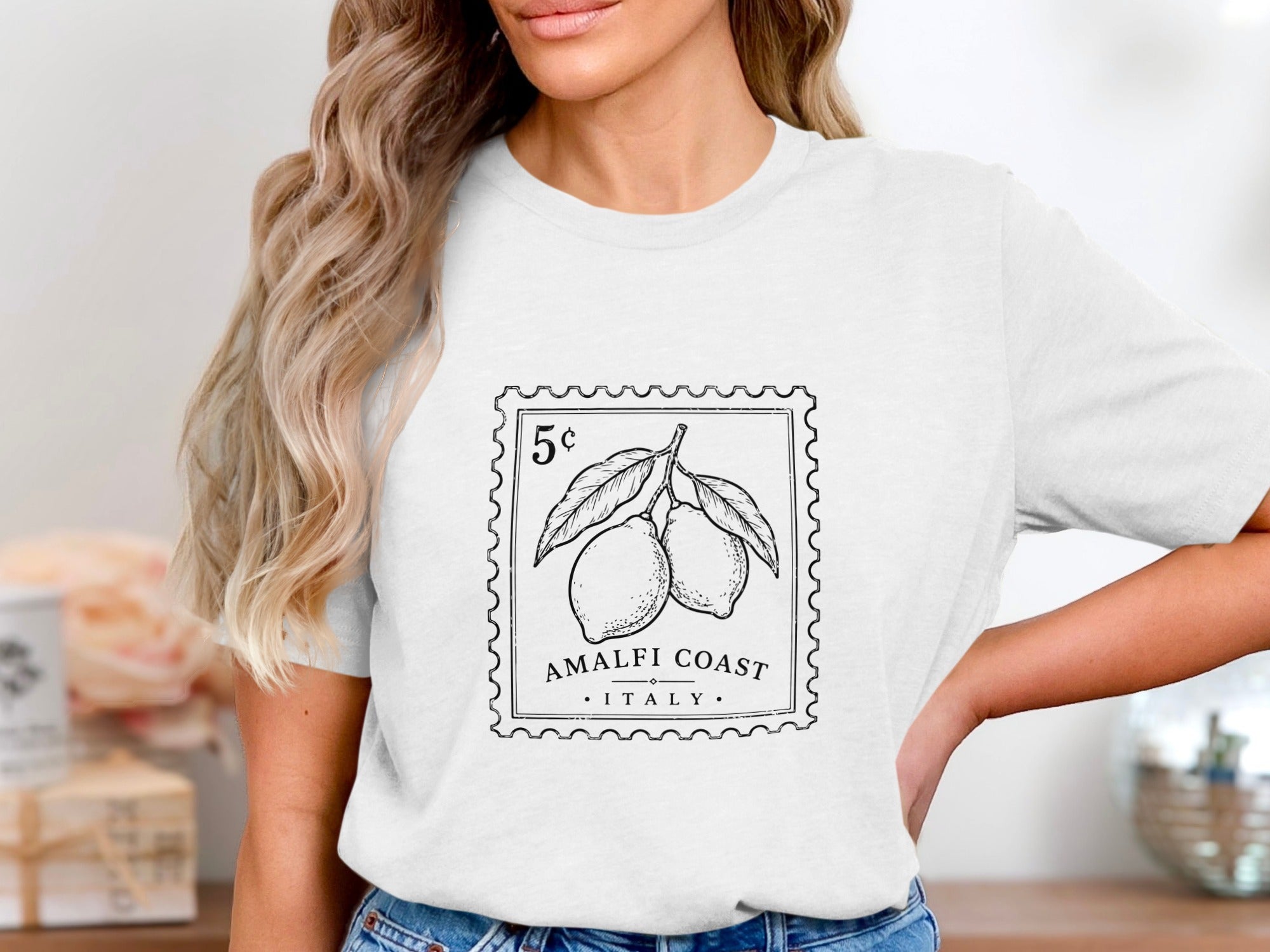 White t-shirt with a postage stamp graphic featuring lemons and "Amalfi Coast Italy".