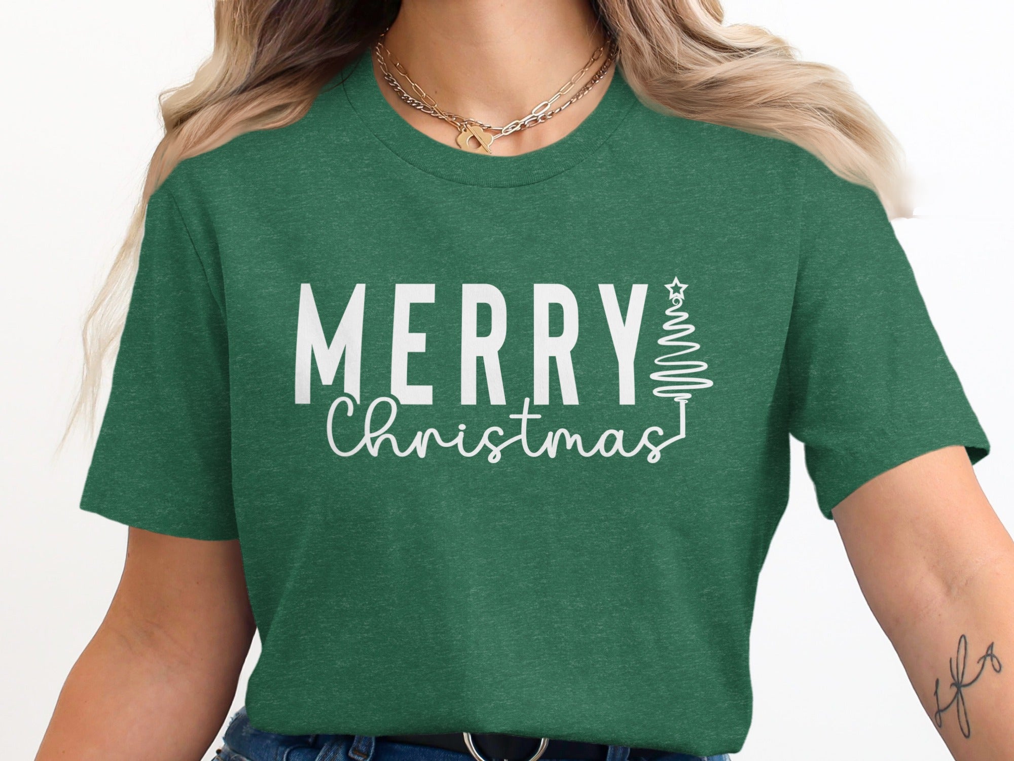 Green t-shirt with white text that says "MERRY Christmas" and a festive tree outline.