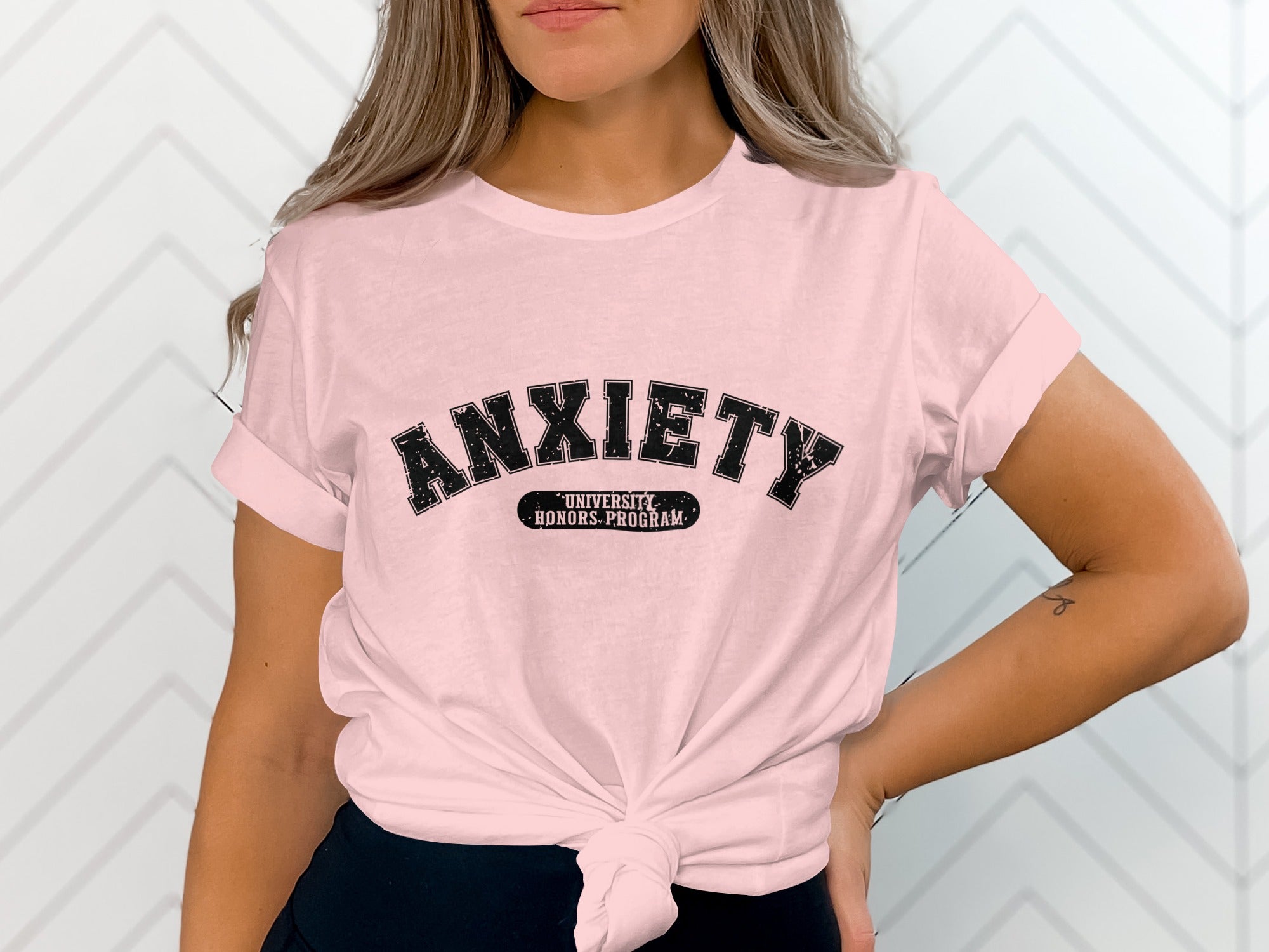 Pink t-shirt with black text reading "ANXIETY UNIVERSITY HONORS PROGRAM".