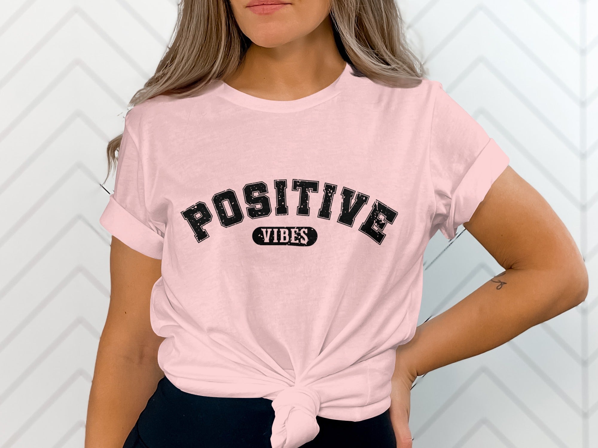 Pink t-shirt with "POSITIVE VIBES" graphic in distressed black lettering.