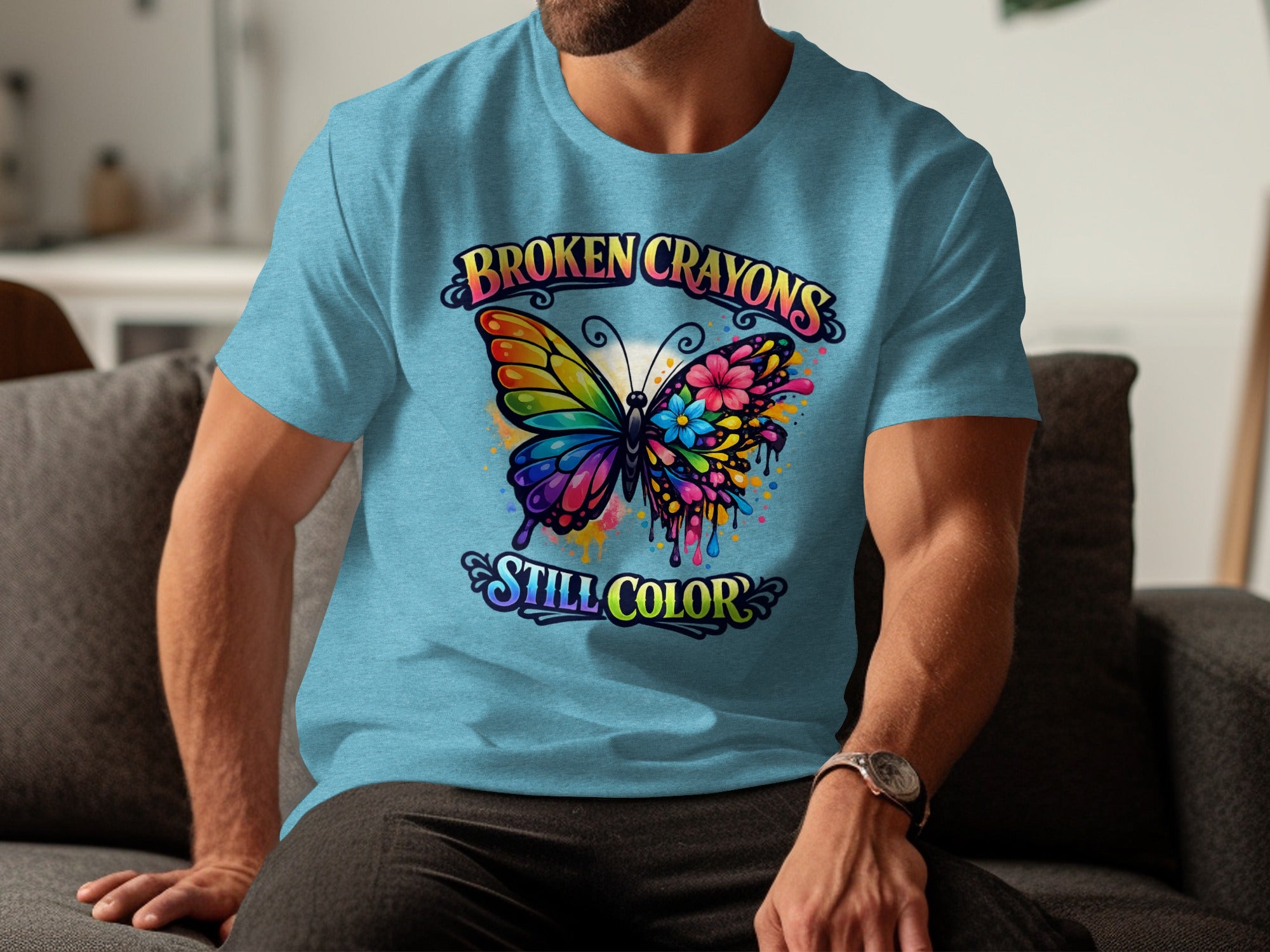 Light blue t-shirt with a graphic of a colorful butterfly and the text "BROKEN CRAYONS STILL COLOR".