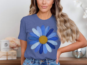Blue t-shirt with textured blue daisy graphic and gold center.